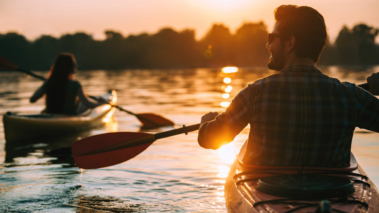 A couple kayaking on a lake in the evening light