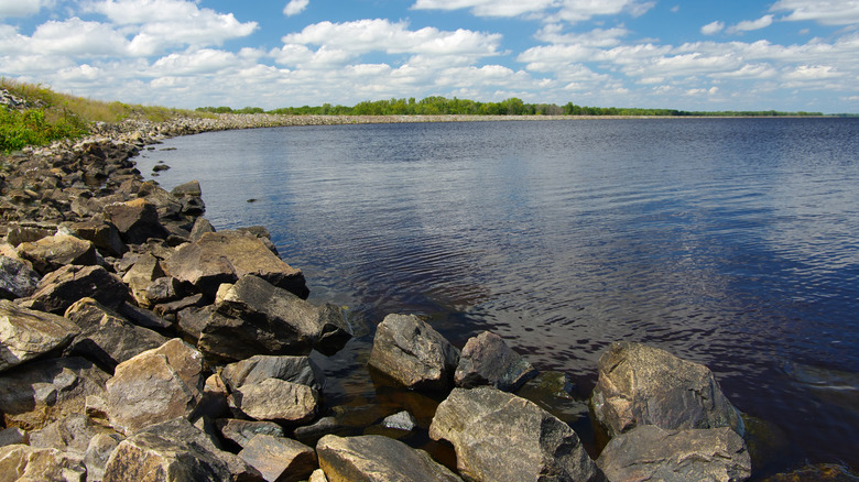 rocky shoreline of Petenwell Lake with trees in the distance