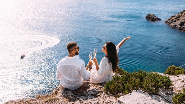 couple drinking champagne seaside