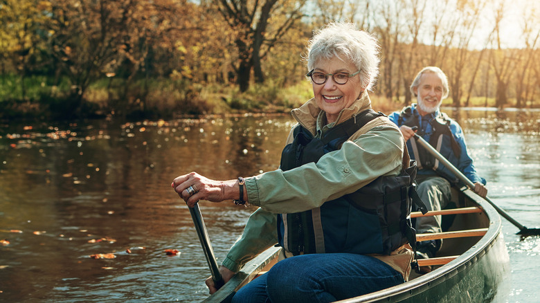 older couple paddling canoe