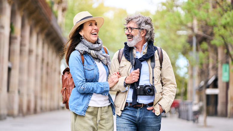 older couple with photography equipment traveling