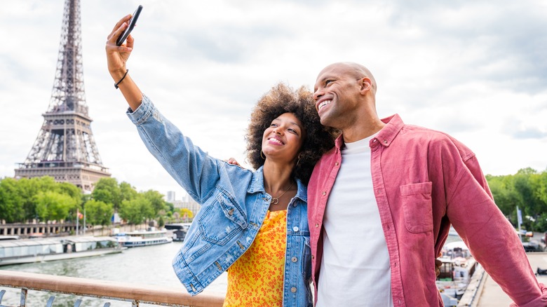 Happy couple taking photo in Paris