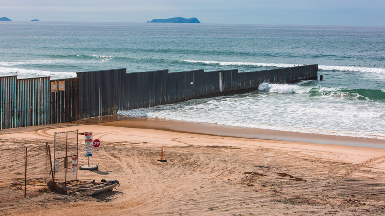 A fence from the sand into the ocean at Border Field State Park in California