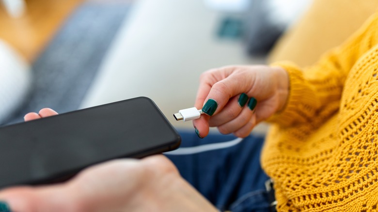 Woman plugs in cell phone