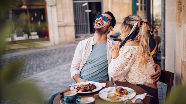Couple laughing at table