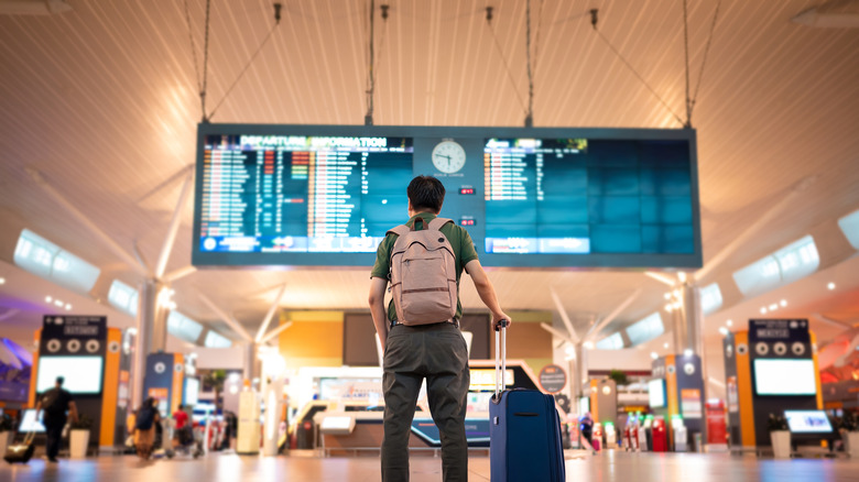 man standing in airport concourse