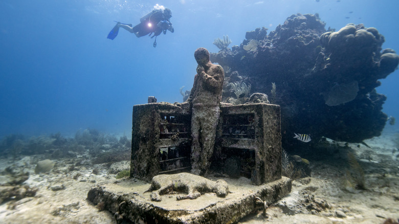 Diver swimming near statue